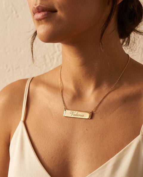Collar de placa dorada con el nombre Valeria puesto
